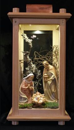 the nativity scene is displayed in a glass case