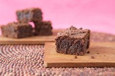 two pieces of brownie sitting on top of a wooden cutting board