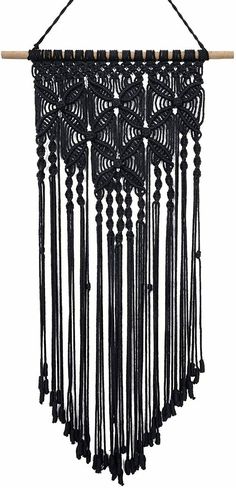 a black macrame hanging on a wall