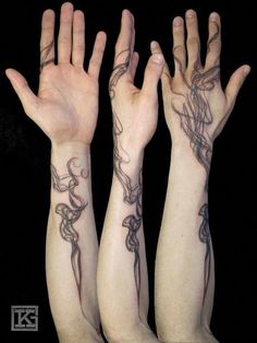 two hands with tattoos on their arms