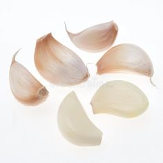 four pieces of garlic on a white background