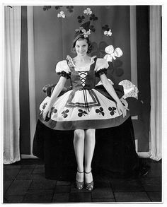 a black and white photo of a woman wearing a dress with flowers on the skirt