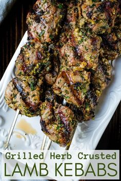 grilled herb crusted lamb kebabs on a white platter with text overlay