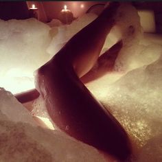 a woman laying down in a bath filled with ice