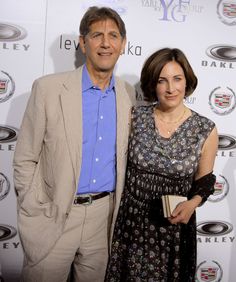 a man and woman standing next to each other on a red carpet at an event