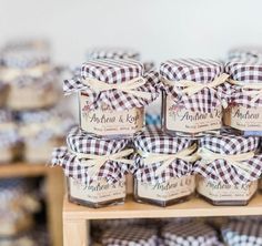 many jars are stacked on top of each other and tied with ribbon around the lids