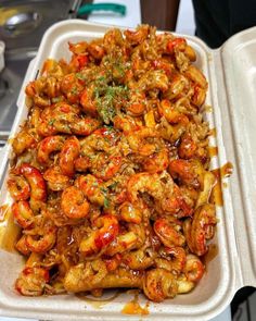 a tray filled with shrimp and broccoli covered in sauce