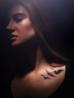 a woman's shoulder with birds on it and the word love written across her chest