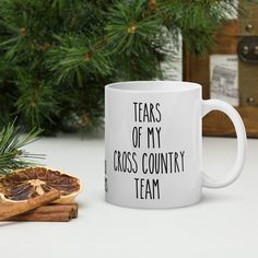 a white coffee mug that says tears of my softball team next to some cinnamons