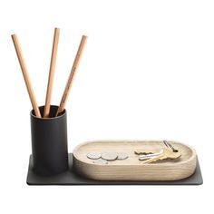 a wooden tray with pencils, coins and keys in it on a white background