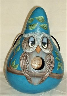 a blue ceramic bird with green leaves on it's head