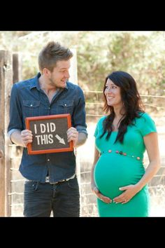 a pregnant woman holding a sign with the words i did this written on it while standing next to a man