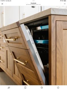 an appliance that is open to show the kitchen's drawers and cupboards