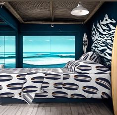 a bed room with a neatly made bed and two surfboards hanging from the ceiling