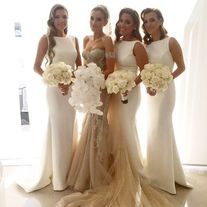 the bridesmaids are all dressed up in white and gold gowns, holding their bouquets