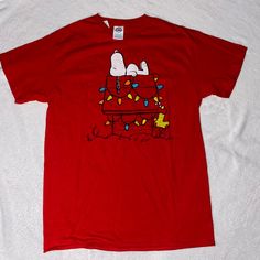 a red t - shirt with peanuts on the back and lights all over it's chest