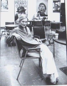 a black and white photo of a woman sitting in a chair