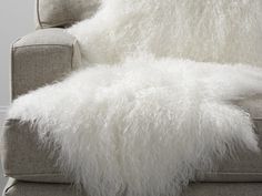 a fluffy white furry blanket sitting on top of a couch