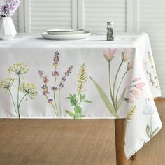 a white table cloth with flowers painted on it