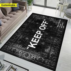 a rug with the words keep off on it in black and white, next to a couch