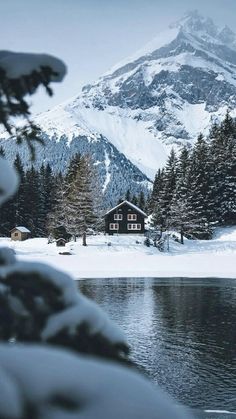 a snowy mountain with a house in the foreground