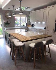 a kitchen island with four stools in front of it