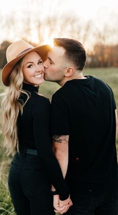 a man and woman standing next to each other in a field