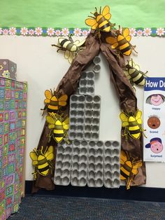 a bulletin board with bees on it in front of a building made out of egg cartons