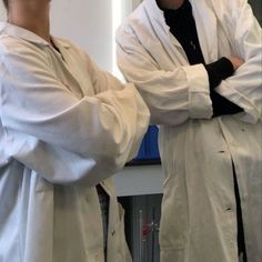 two people in lab coats standing next to each other