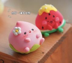 two small toy animals sitting on top of a wooden table with words written in chinese