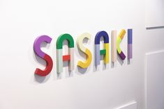 the word sasak spelled in multicolored letters on a white wall