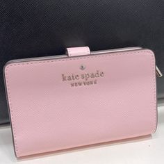 Kate Spade Staci Medium Compact Bifold Wallet Conch Pink Color: Conch Pink New With The Tag Authentic 4.5" H X 5.5" W X 1" D Saffiano Leather Ksny Metal Pinmount Logo Two Way Spade Jaquard Lining Interior: 8 Credit Card Slots, Id Window, 4 Slip Pockets, 2 Bill Folds Exterior: L-Zip Coin Compartment Snap Closure Dust Bag Not Included Imported Style # Kc580 #Chalk Pink Kate Spade Chalk Pink, Kate Spade Pink Wallet, Kate Spade Wallet Pink, Kate Spade Staci, Xmas List, Barbie Stuff, Jewelry Tattoo, Pink Cards, Black Leather Wallet