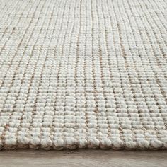 an area rug on the floor with white and beige colors, close - up view