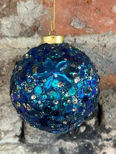 a blue ornament hanging on a brick wall