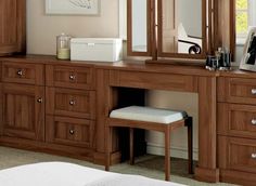 a bedroom with a vanity, mirror and stool