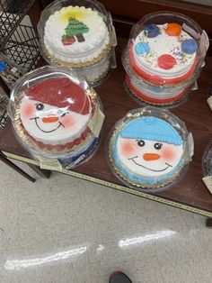 there are many frosted cakes in the box on the table and one has a snowman