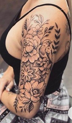 a woman's arm with flowers and leaves tattooed on the back of her shoulder