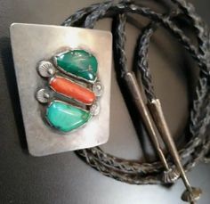 This Dan Simplicio Bolo features 2 natural “greasy green” turquoise cabs, & a piece of coral set on solid silver with handsomely stamped raindrops and signature Simplicio filed bezels. Earliest Bennett Clasp, probably dating to the late 50s. All hand made, & the tips are extra long with great fluted hogan beads, also hand stamped at top. A Zuni silversmith, Dan Simplicio (1917-1969) learned the art of jewelry making from his uncle, Juan DeDios, one of the earliest Zuni silversmiths. Although thi Rain Drops, Extra Long, Muse, Hand Made, Coral