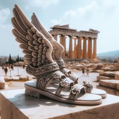 a pair of sandals sitting on top of a stone block in front of an ancient temple