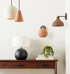 three lamps are hanging on the wall above a table