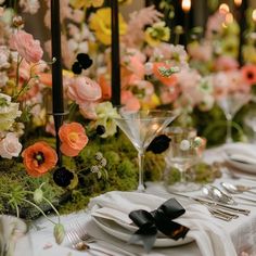 the table is set with flowers, candles and place settings for an elegant dinner party