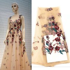 a mannequin wearing a dress with flowers and butterflies on it next to a card