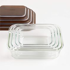 three glass containers with wooden lids are stacked on top of each other