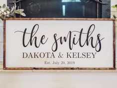 a wooden sign that says the smiths and dakota & kelsey