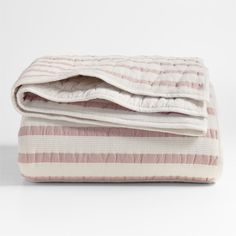 the pink and white striped blanket is folded up