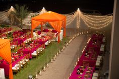 an outdoor event set up with pink and orange linens