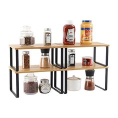 three wooden shelves with spices and condiments on them, one shelf is black