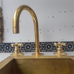 a gold sink with two faucets on the side