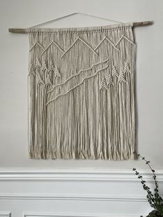 a white wall hanging on the side of a fireplace