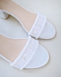 a pair of white shoes with lace on the top and bottom, sitting on a table